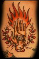 Tatuaje de una mano con un ojo dentro y fuego en los dedos