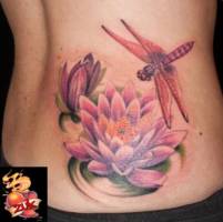 Tatuaje de una libélula rondando una flor de Loto