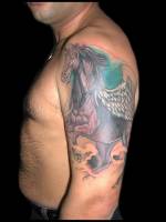 Tatuaje de un unicornio alado en el brazo