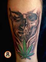 Tatuaje de una calavera y una flor de marihuana