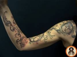 Tatuaje para mujeres. Tatuaje en el brazo  de sanefas y plantas