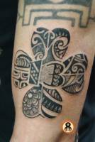Tatuaje de un trébol  con el número 13, de estilo maorí