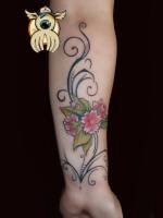 Tatuaje de un brazalete hecho con lineas finas y unas flores