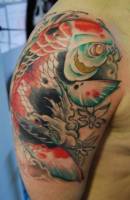 Tattoo de Koi en el brazo con olas y flores
