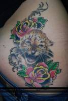 Tatuaje de un cachorro de tigre con algunas flores