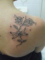 Tatuaje de unas flores con una libélula