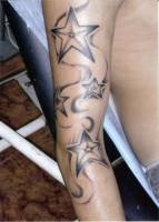 Tatuaje de estrellas bajando por el brazo
