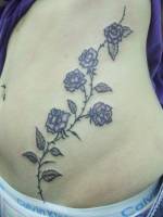 Tatuaje de unas flores  por la barriga de una chica
