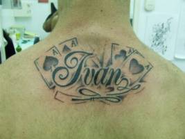 Tatuaje de un nombre con unas cartas