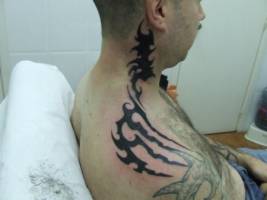 Tatuaje de un tribal que sube por el cuello hasta casi la oreja