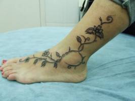 Tatuajes de una planta en el pie, con algunas flores