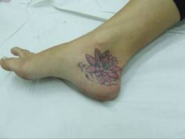 Tatuaje para mujer de una flor en el talón