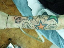 Tatuaje de estrellas y flores en el brazo