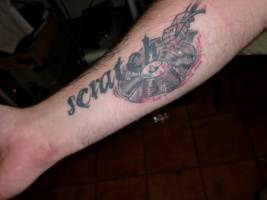 Tatuaje de la palabra scratch y un disco
