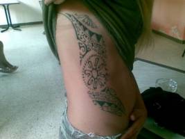 Tatuaje maori en el costado de una mujer
