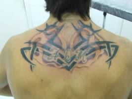 Tatuaje de un tribal con unas iniciales