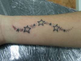 Tatuaje de pequeñas estrellas en el brazo