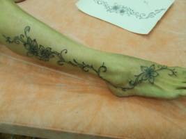 Tatuaje de unas flores subiendo por la pierna