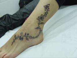 Tatuaje de una enredadera en el pie de una mujer