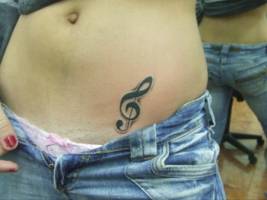 Tatuaje de una clave de sol en la barriga de una chica