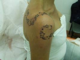 Tatuaje de una linea de estrellas en el hombro de una chica