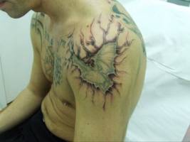 Tatuaje de un murciélago en el brazo