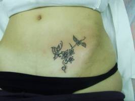 Tatuaje de unas flores en la barriga de una chica
