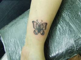 Tatuaje de una mariposa en la muñeca