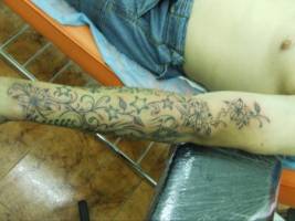 Tatuaje en el brazo de enredaderas y estrellas
