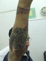 Tatuaje de una cruz celta debajo del brazo