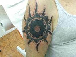 Tatuaje de un gran sol en el brazo