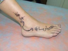 Tatuaje de unas sanefas y una frase en árabe