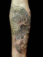 Tatuaje de una gran carpa rodeada de olas
