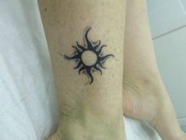 Tatuaje de un sol encima del tobillo