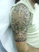 Tatuaje en el brazo de estética maorí con el numero 13 enmedio