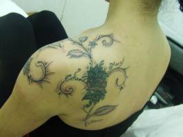 Tatuaje para mujer de unas flores en la espalda