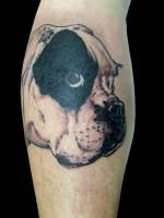 Tatuaje de una cabeza de perro en el gemelo