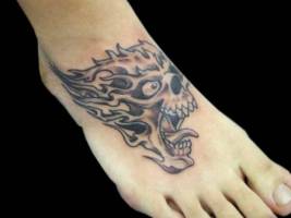 Tatuaje de una calavera en llamas para el pie