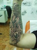 Tatuaje de una cara de monstruo en el brazo