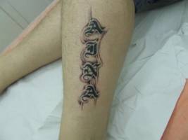 Tatuaje de un nombre en la pierna con letras góticas