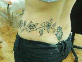 Tatuaje de unas flores en la cadera