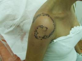Tatuaje de una espiral de estrellas en el hombro de una mujer