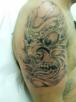 Tatuaje de la cara de un monstruo en el brazo