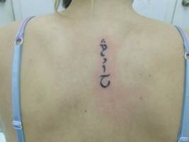 Tatuaje de unas letras en la espalda