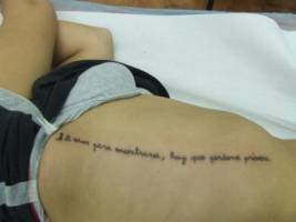 Tatuaje de una frase en el costado