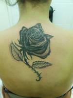 Tatuaje de una rosa en la espalda de una mujer