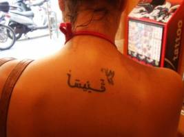 Tatuaje de letras árabes en la espalda