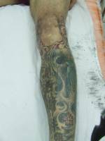 Tatuaje de olas y kanjis en la pierna