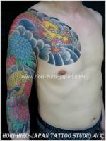 Tatuaje de un dragón japonés en el brazo y pecho. Tatuaje a color