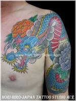 Tatuaje de un dragón con algunas flores de loto
